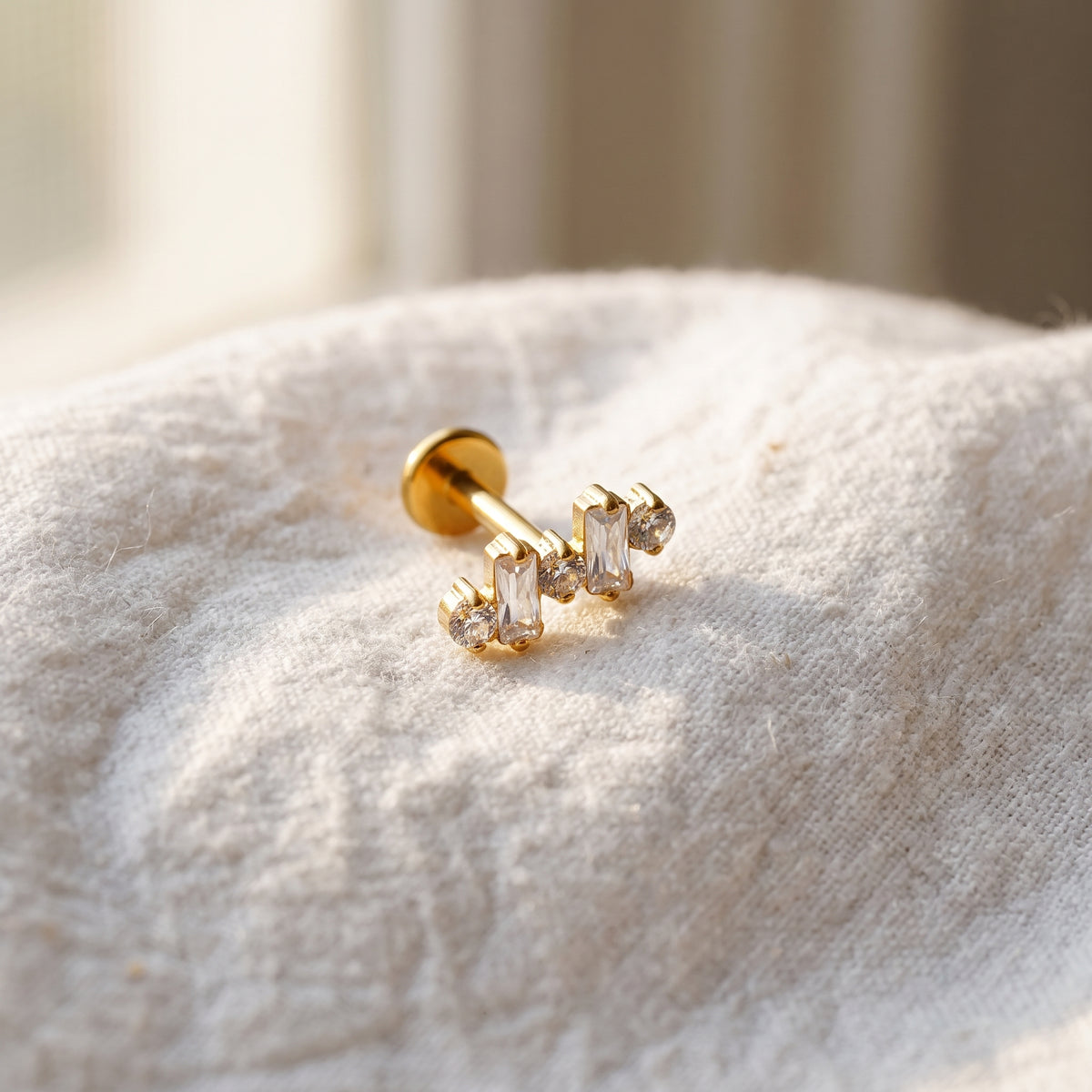Styled shot of the titanium baguette CZ ear climber stud shown for helix and conch piercings