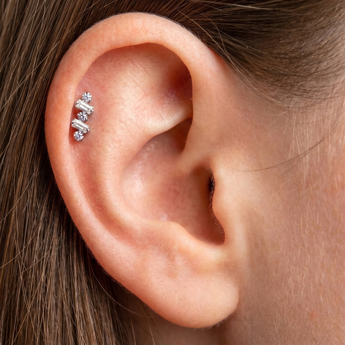 Close-up of the baguette-cut CZ crawler setting on the titanium ear climber stud, showing the finish detail