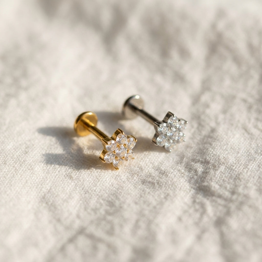 Styled shot of the titanium CZ (cubic zirconia) flat-back labret stud shown for forward helix, tragus and conch piercings