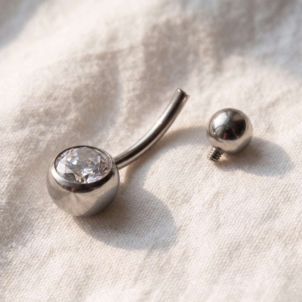 Styled shot of the titanium internally threaded belly button ring shown for navel piercings