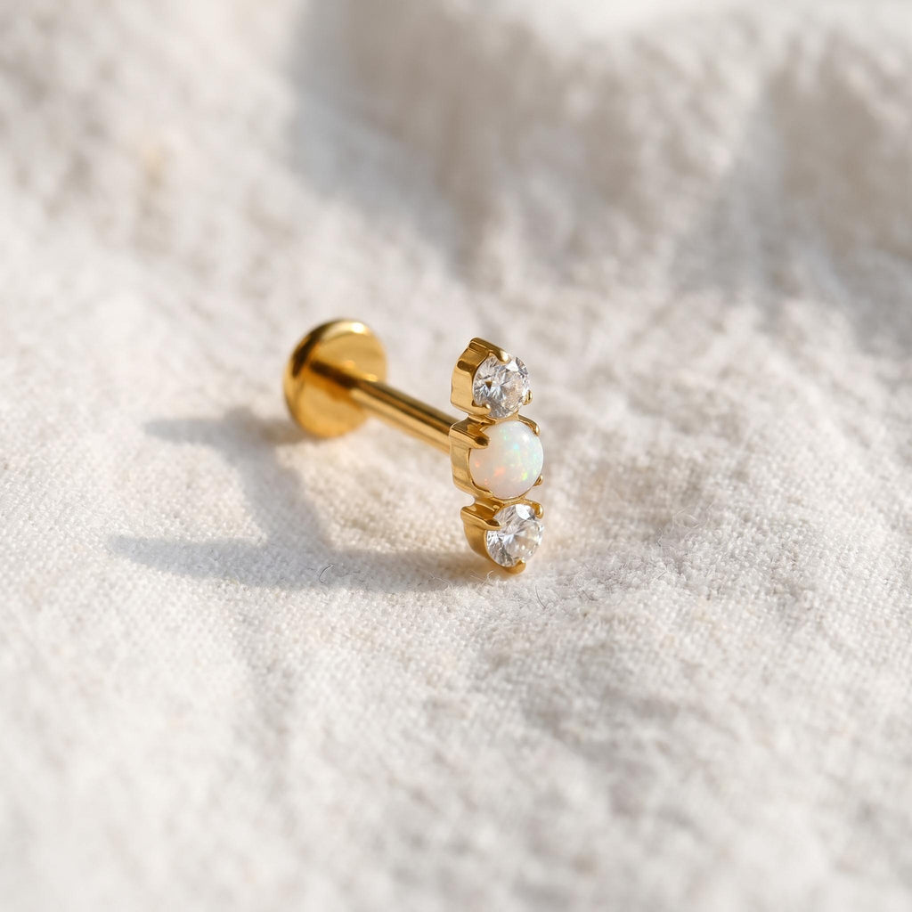 Styled shot of the titanium triple opal stud shown for helix and tragus piercings