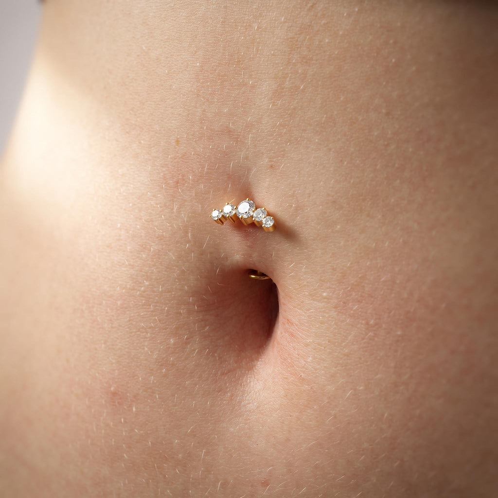 Close-up of the five graduated CZ stones on the titanium flat-bottom navel barbell, showing the finish detail