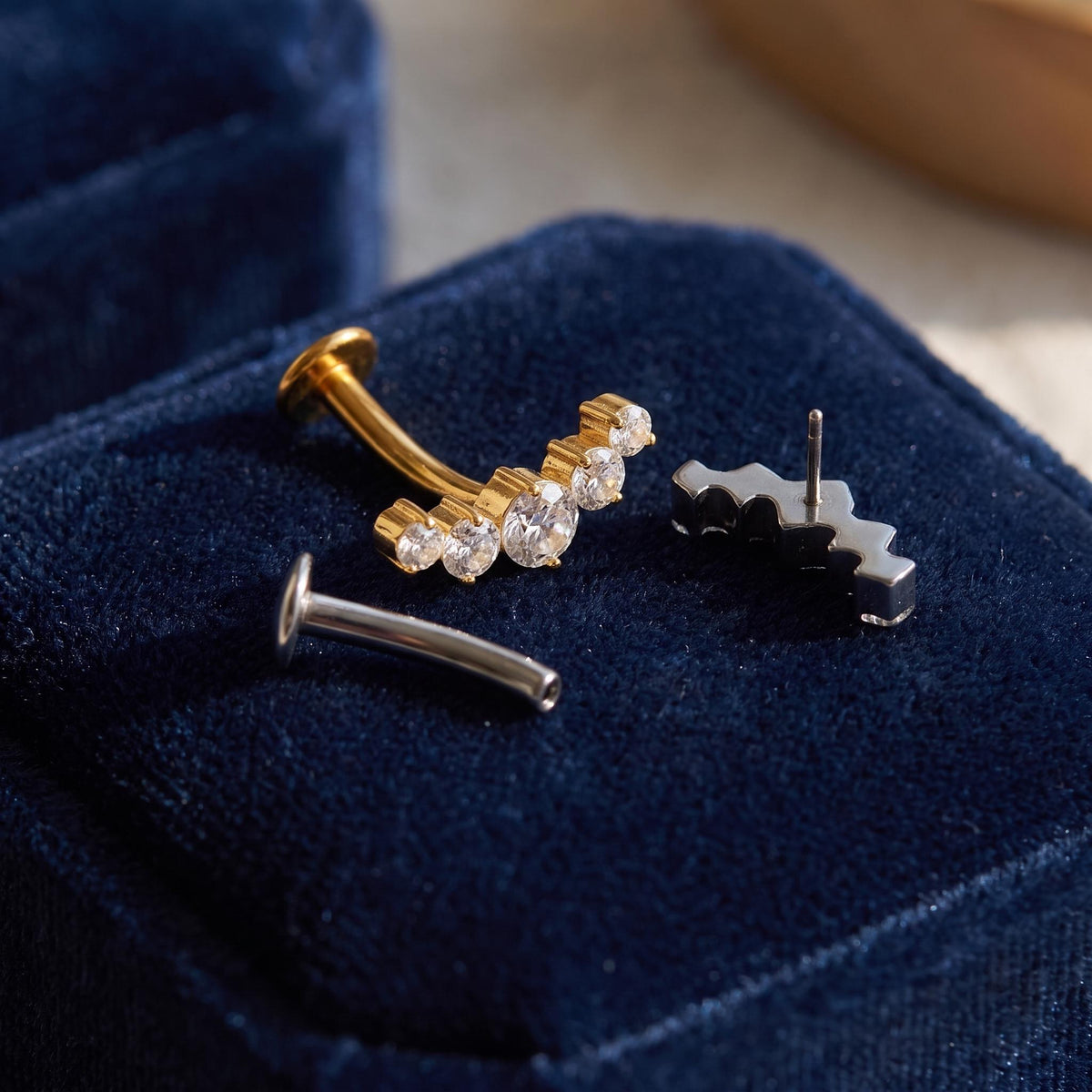 Styled shot of the titanium floating 5-CZ belly ring shown for navel piercings