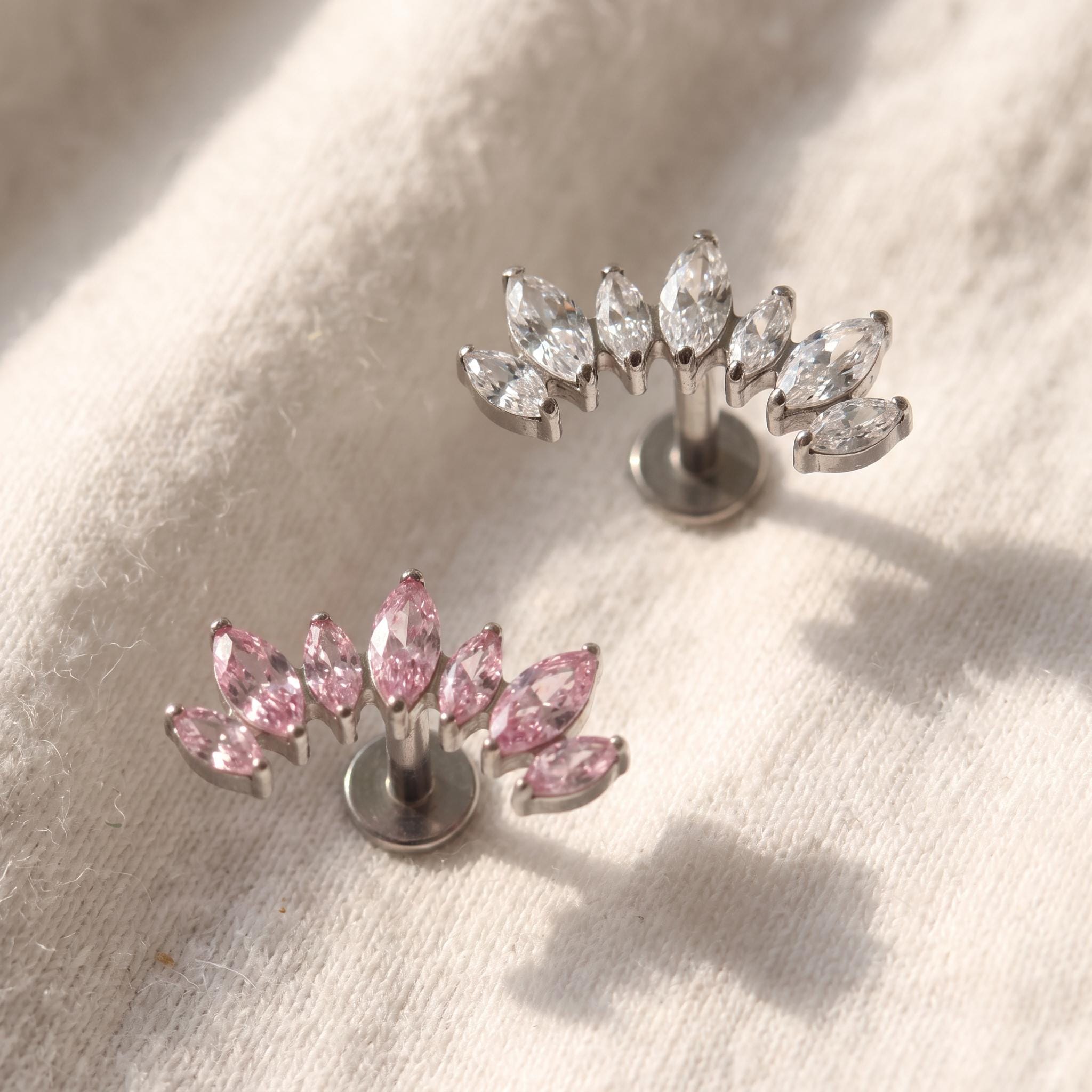 Styled shot of the titanium curved marquise ear climber stud shown for helix and tragus piercings