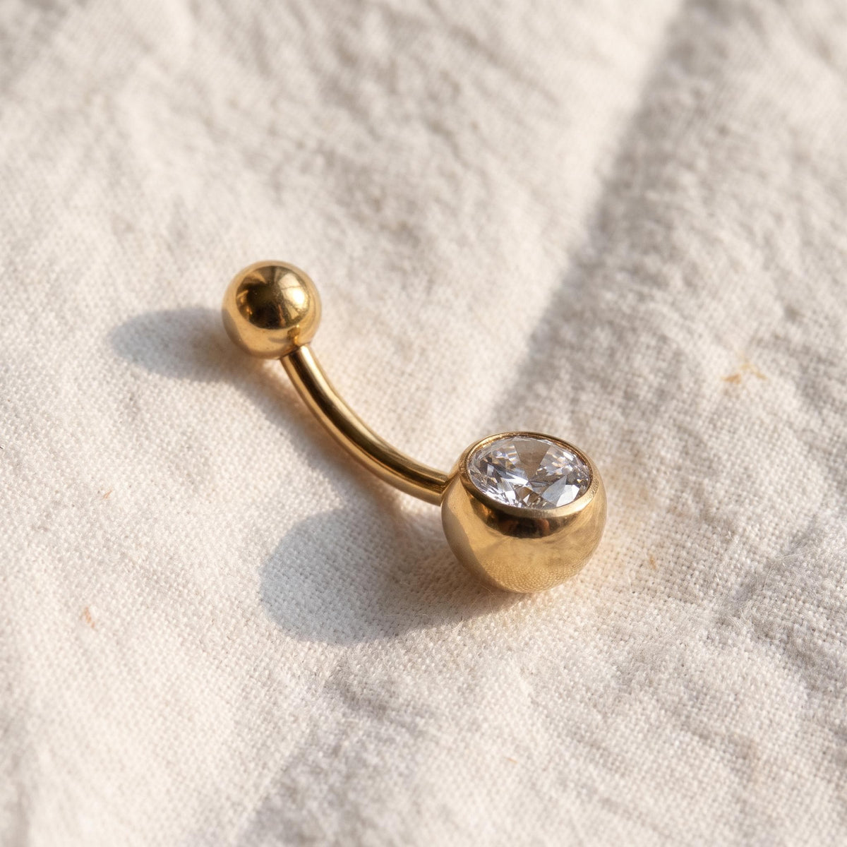 Close-up of the CZ ball end on the titanium internally threaded navel barbell, showing the finish detail